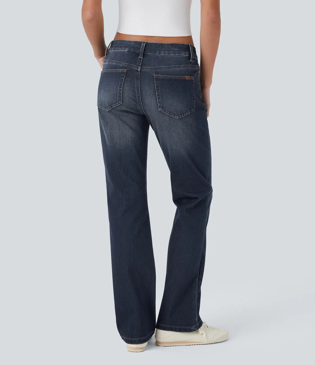Närbild på tyg och sömmar på tvättade blå bootcut-jeans