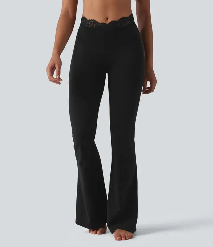 Framifrån visad modell i svarta yogaleggings med utsvängda ben och spetsdetalj