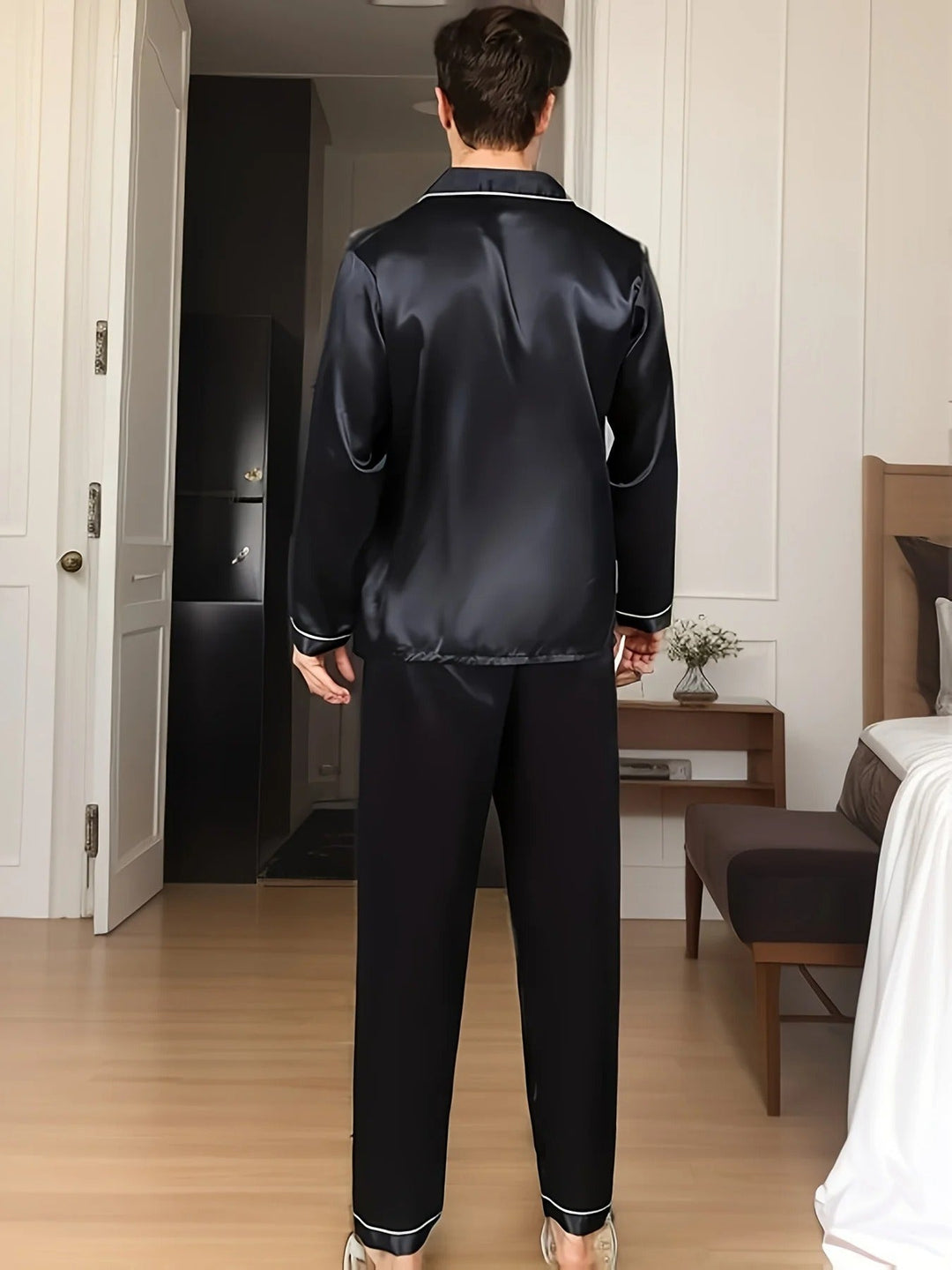 Baksidesbild av man i svart herrpyjamas Adrian