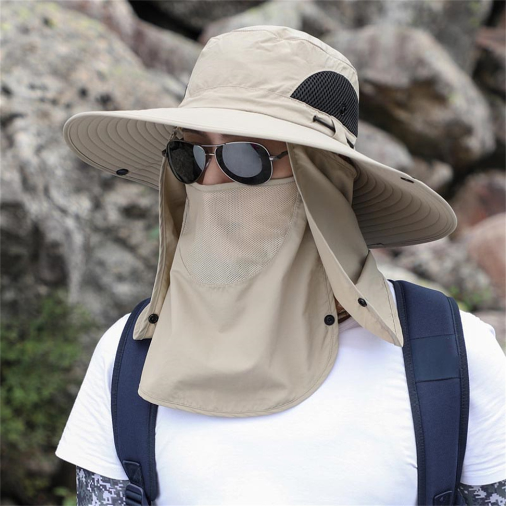Person i khaki solhatt med ansiktsskydd utomhus
