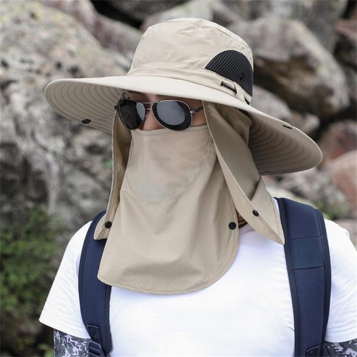 Person i khaki solhatt med ansiktsskydd utomhus