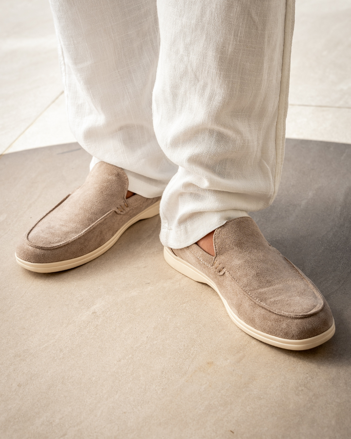 Beige loafers på modell med vita byxor