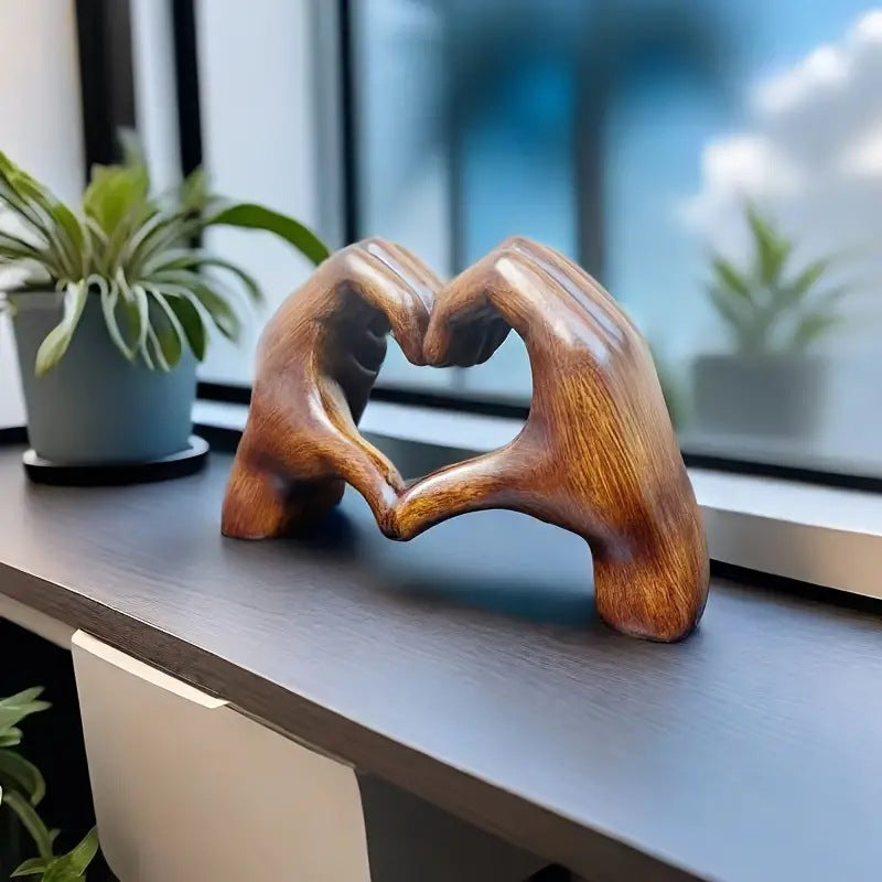Hjärtformad skulptur framför fönster med växt