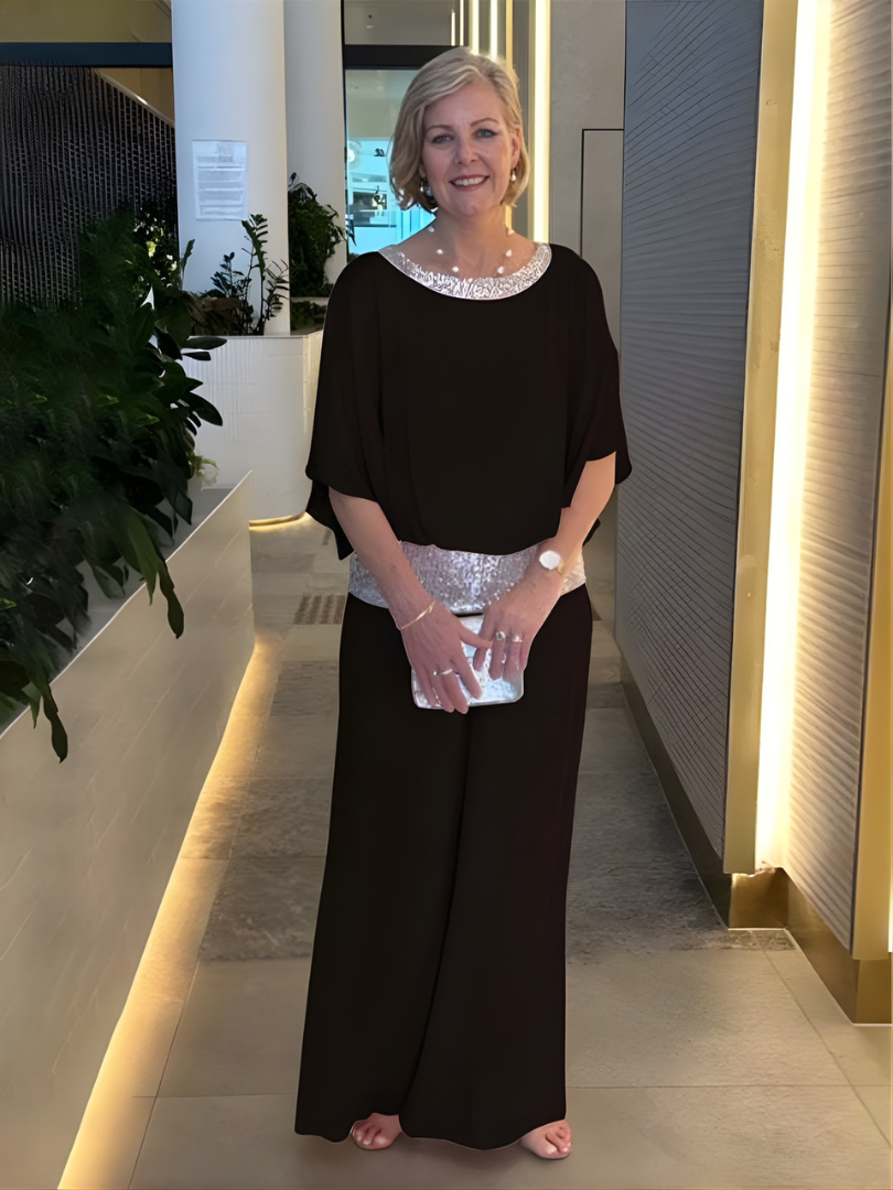 Kvinna i svart elegant set med vida byxor och glittrande midja