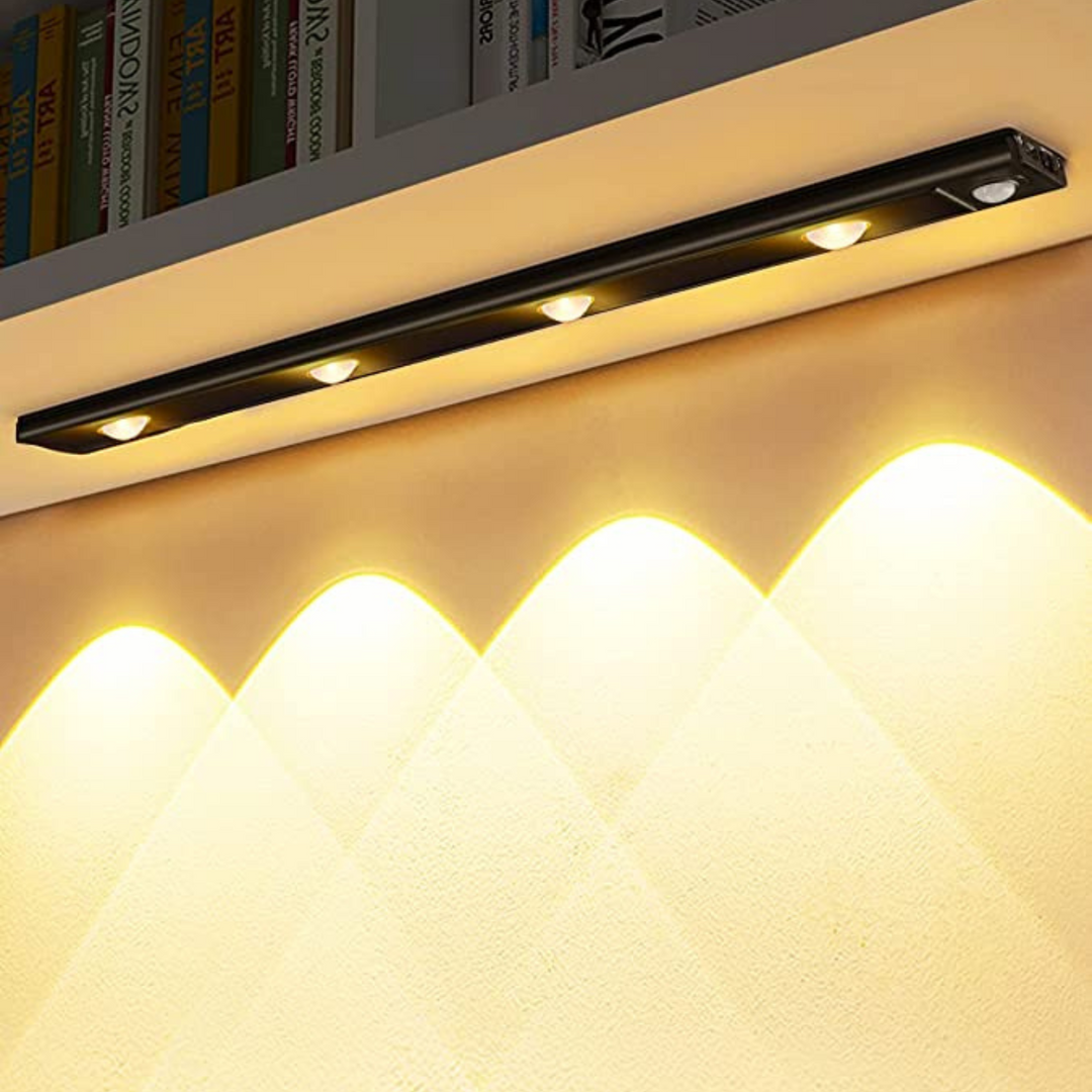 Svart SmartBeam LED-belysning med rörelsesensor installerad i bokhylla
