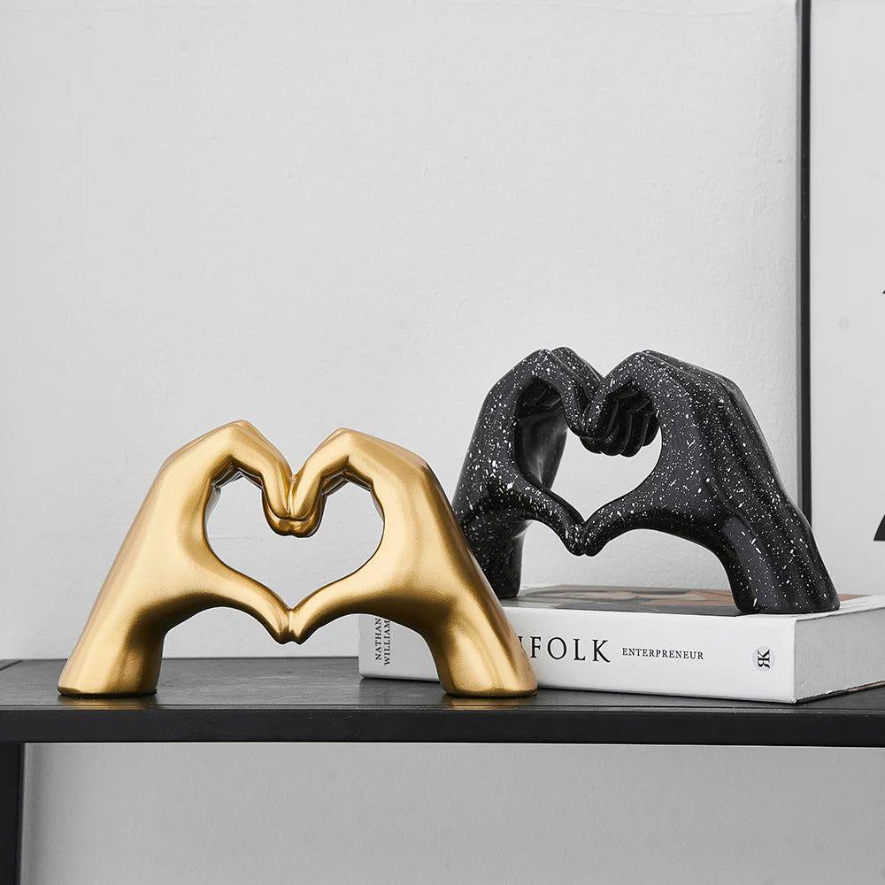 Dekorativ skulptur med hjärta och händer i guld och svart utförande för heminredning