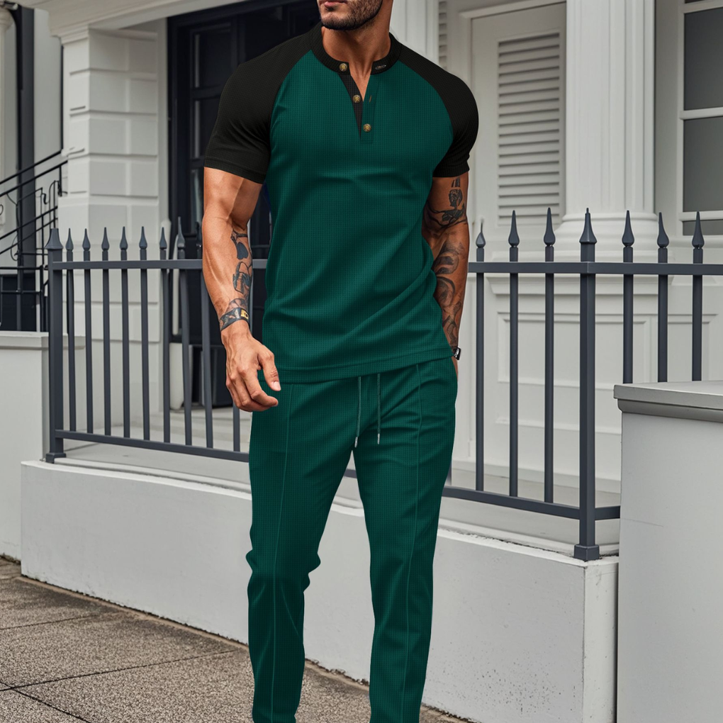 Man iklädd grön kontrast henley t-shirt och matchande joggerbyxor utomhus