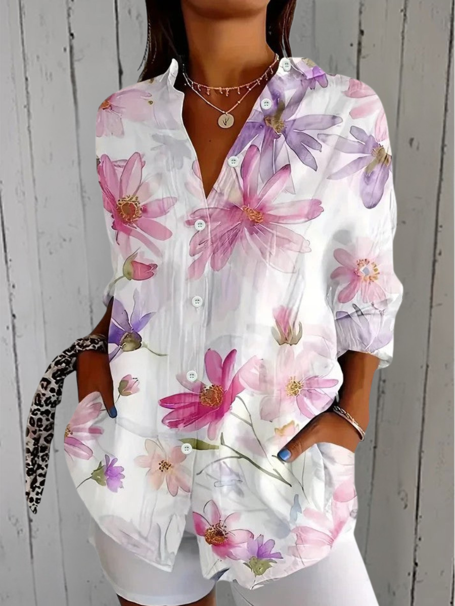 Kvinna som bär en vit damblus med rosa och lila blommor samt knappar