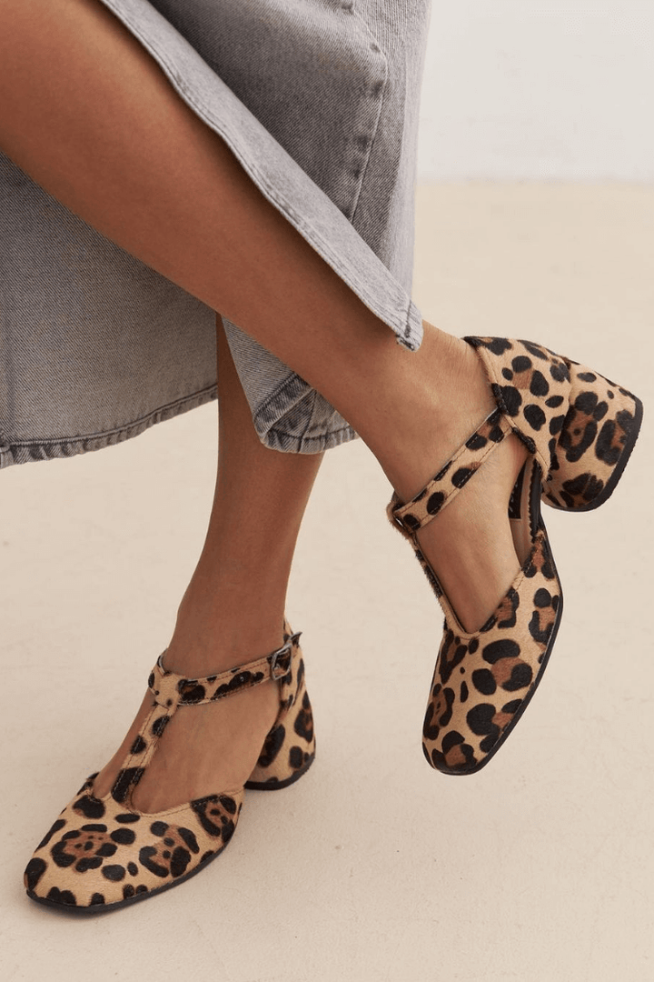 Närbild på leopardmönstrade block heels med spänne runt vristen