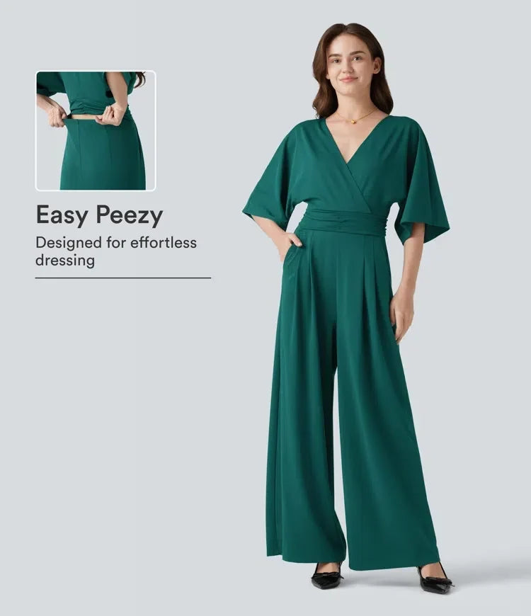 Kvinna som bär grön V-ringad jumpsuit med halvlång ärm framifrån