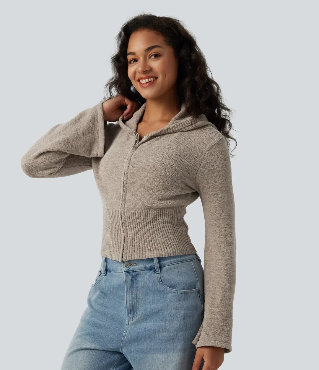 Närbild på modell som bär beiga cardigan med dragkedja