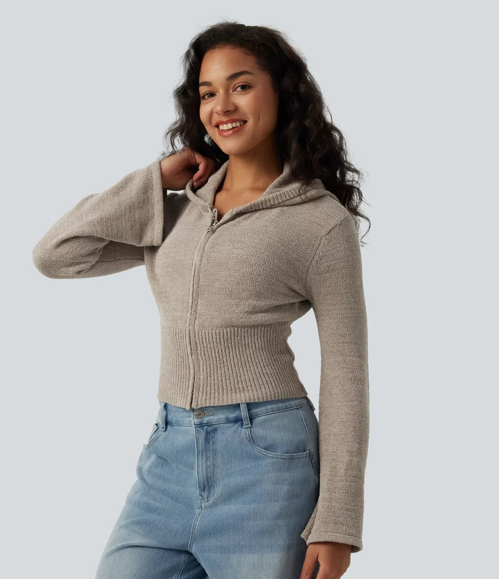 Närbild på modell som bär beiga cardigan med dragkedja