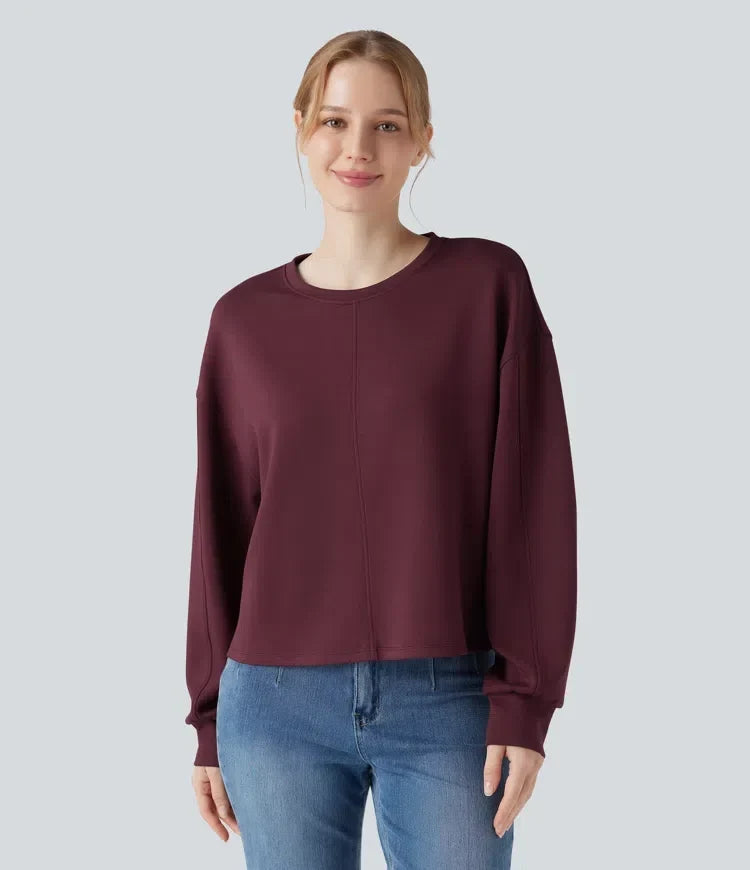 Kvinna som bär en mörkröd sweatshirt med rund hals framifrån