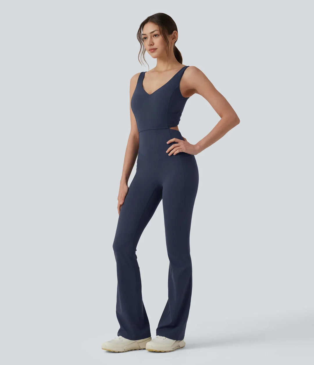 Modell i profil som visar passformen på den utsvängda jumpsuit