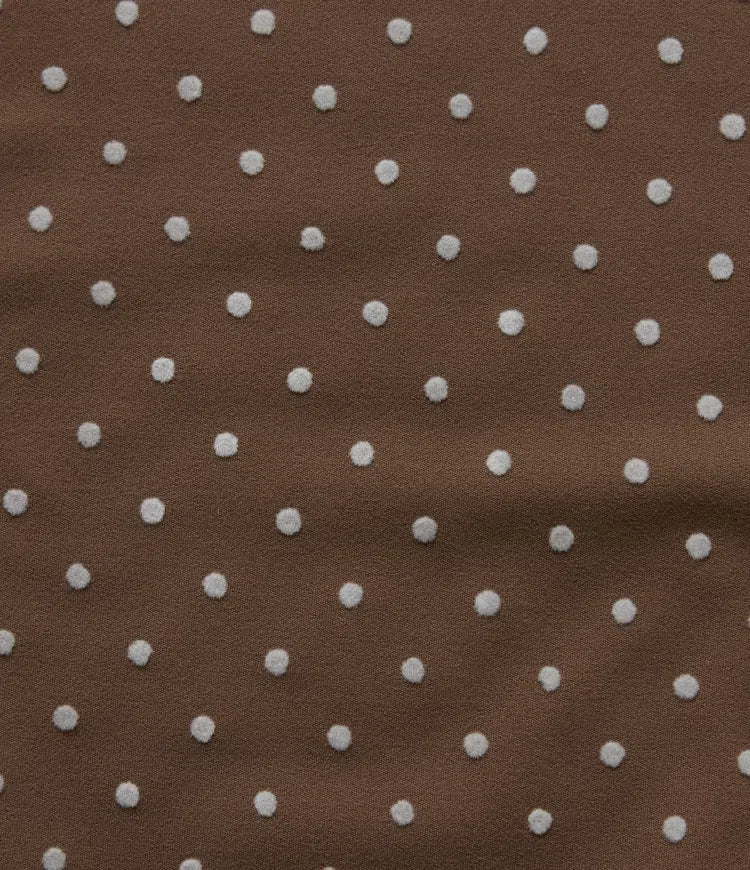 Detaljbild på ficka och mjukt tyg på prickiga yogabyxor