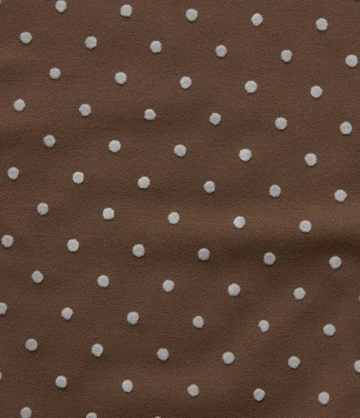 Detaljbild på ficka och mjukt tyg på prickiga yogabyxor