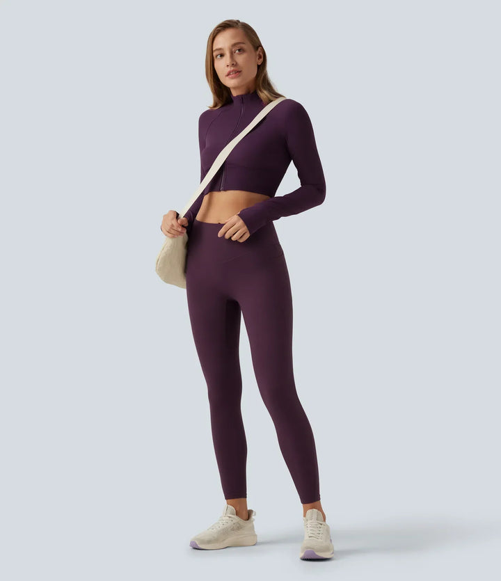 Modell i croppad damjacka för träning och yoga med lång ärm