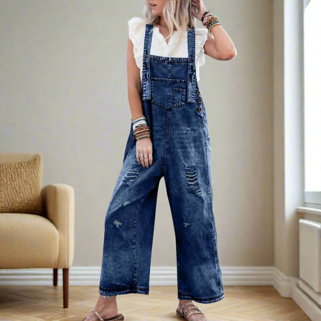 Kvinna som visar blå tvättad vintage jumpsuit med hängslen