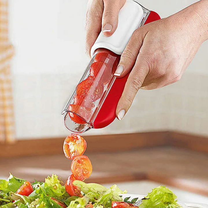 Grönsaksskärare som halverar tomater direkt över en fräsch sallad