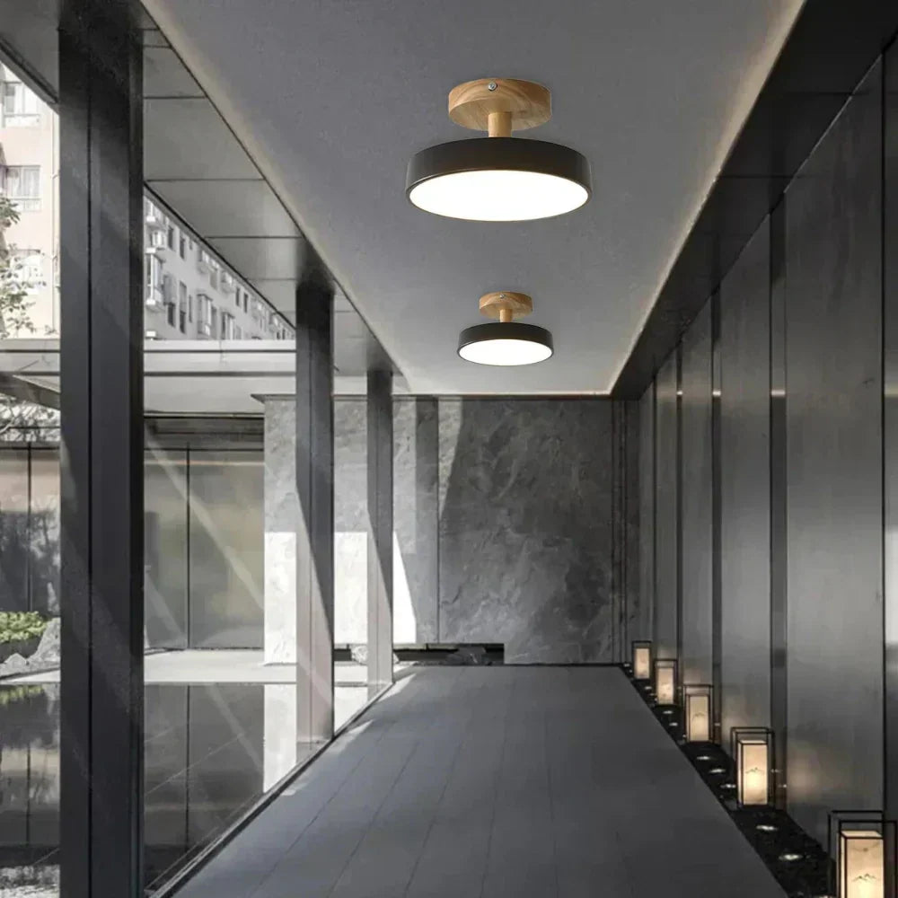 Svart modern LED taklampa i trä installerad i korridor