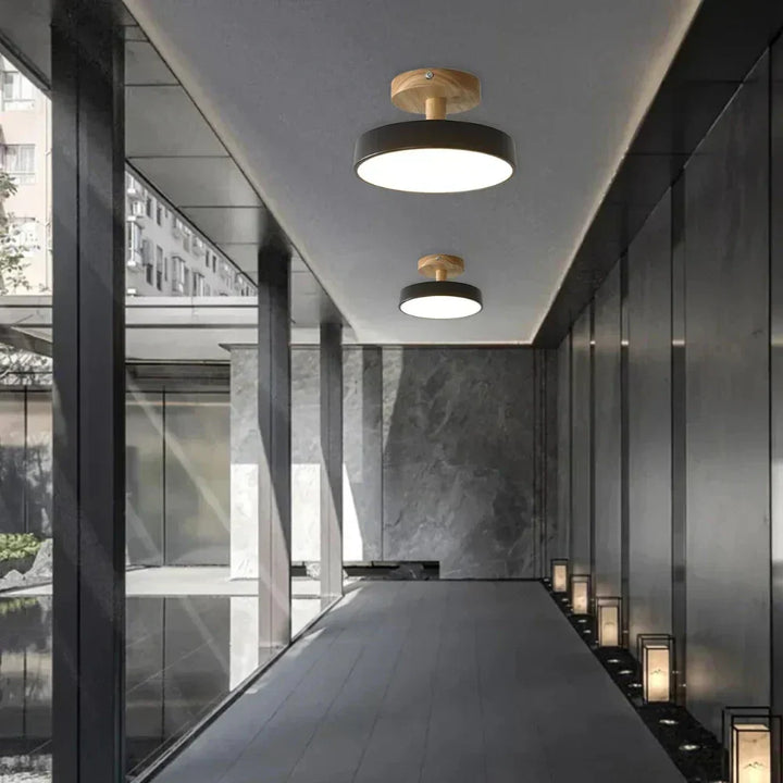 Svart modern LED taklampa i trä installerad i korridor