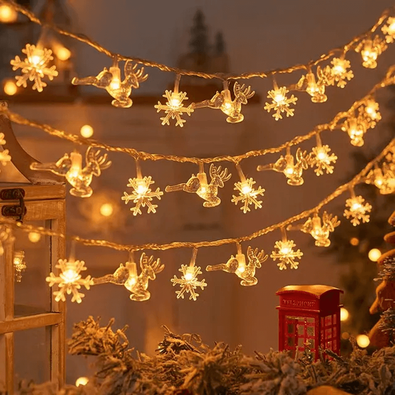 Detaljerad ljusslinga med älg- och snöflingedesign
