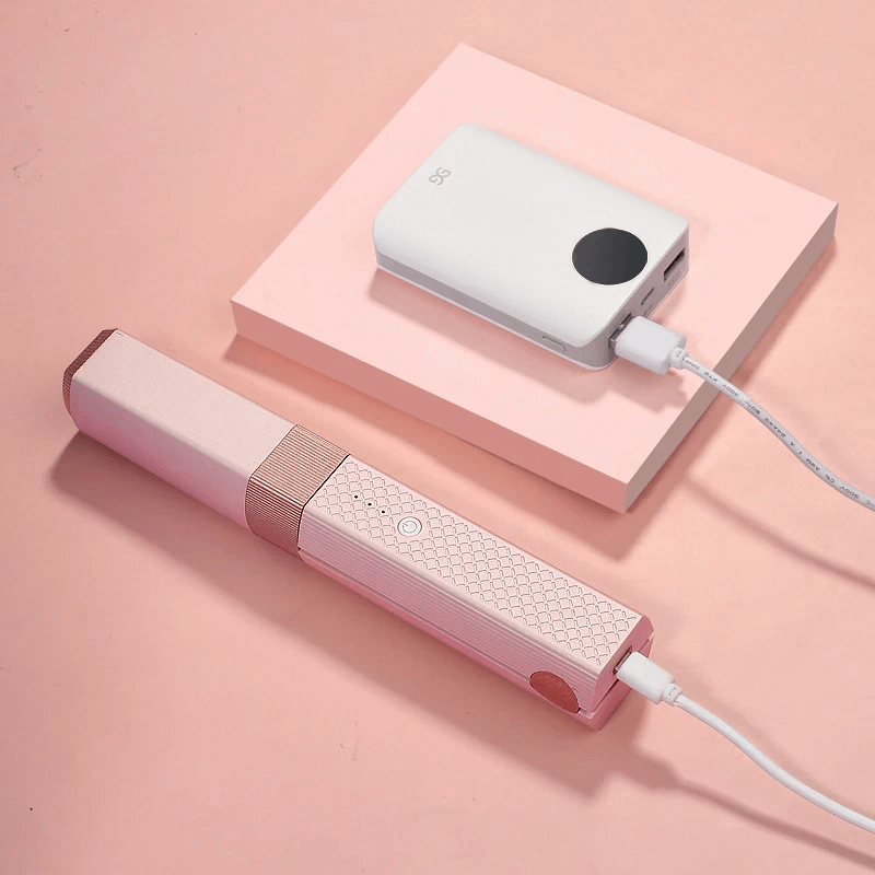 Rosa uppladdningsbar plattång som laddas med USB-kabel från powerbank