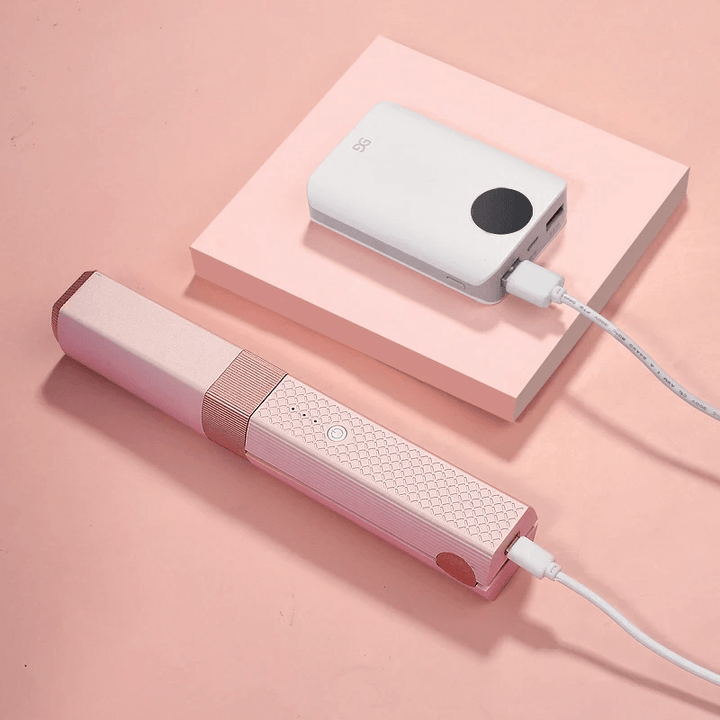 Rosa uppladdningsbar plattång som laddas med USB-kabel från powerbank