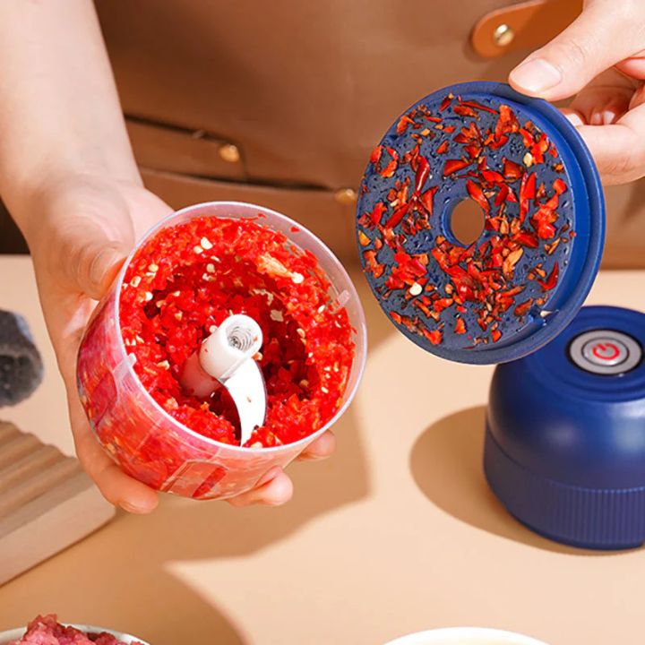 Hårda rostfria blad och hackade röda chilipeppar inuti behållaren