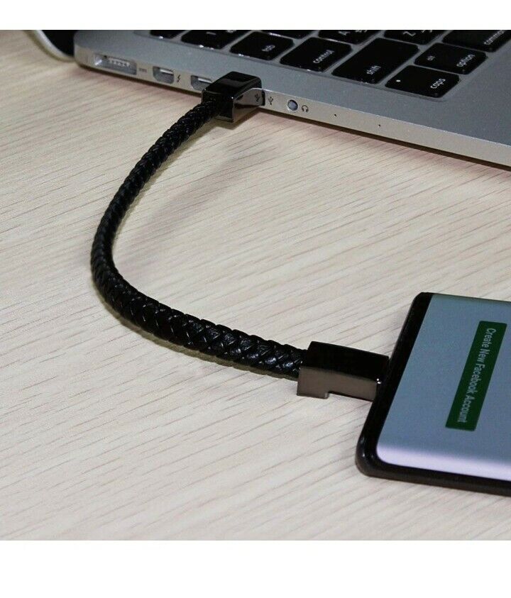 Närbild på laddningsarmband anslutet till en bärbar dator och mobiltelefon