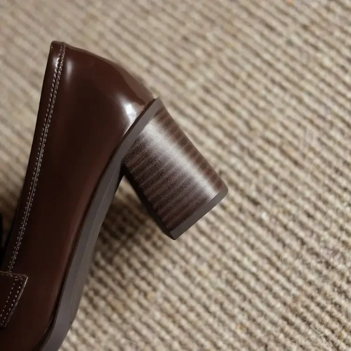Detaljbild på tåparti och tofs på klassiska damloafers i syntetmaterial