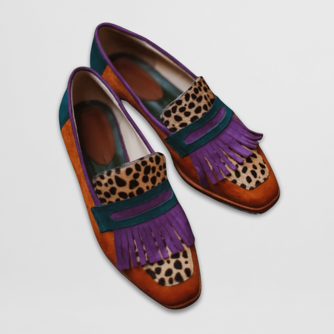 Två par eleganta loafers med fransar placerade på ljust underlag