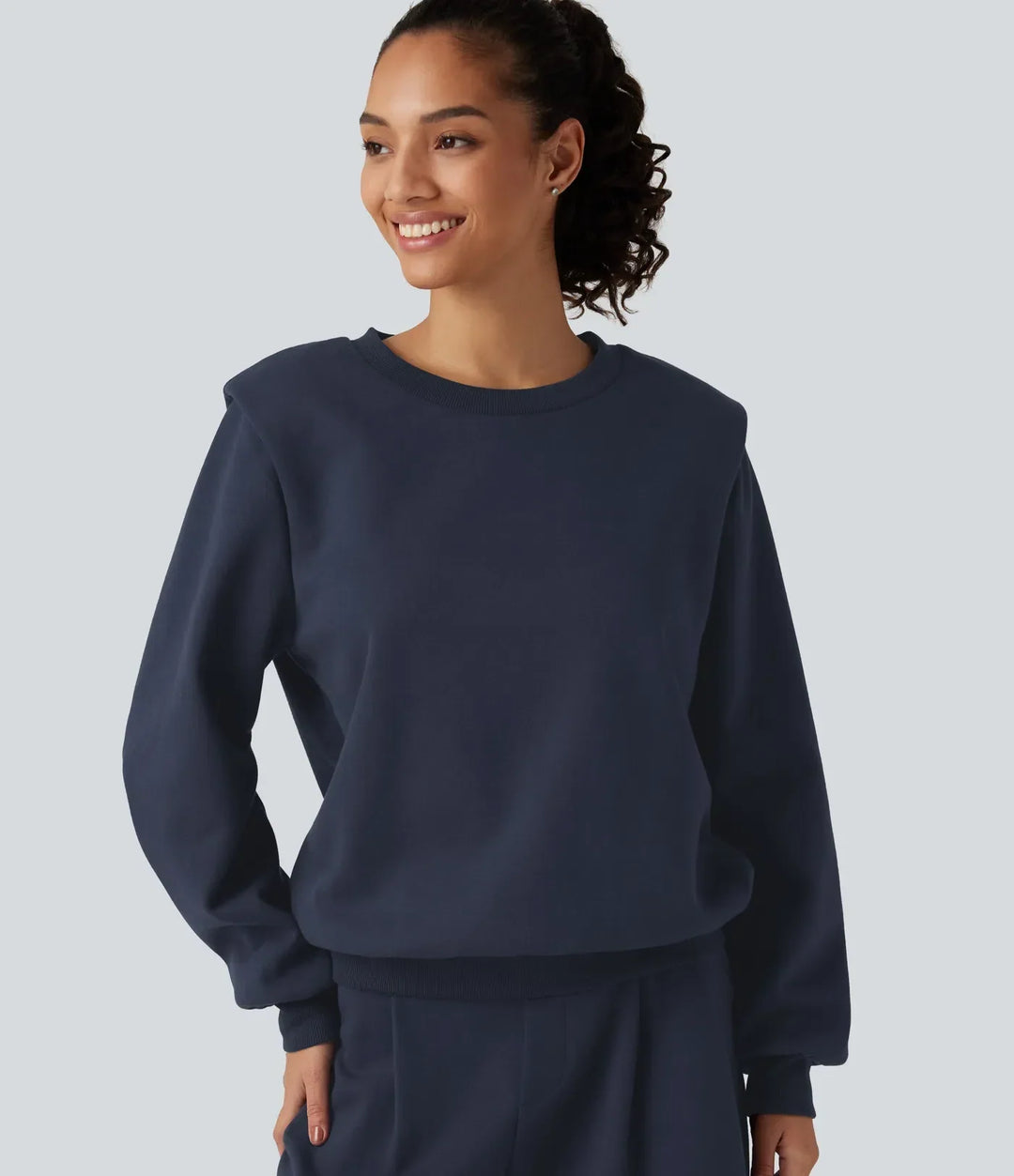 Närbild på mjukt tyg och muddar på blå damtopp i sweatshirtmodell