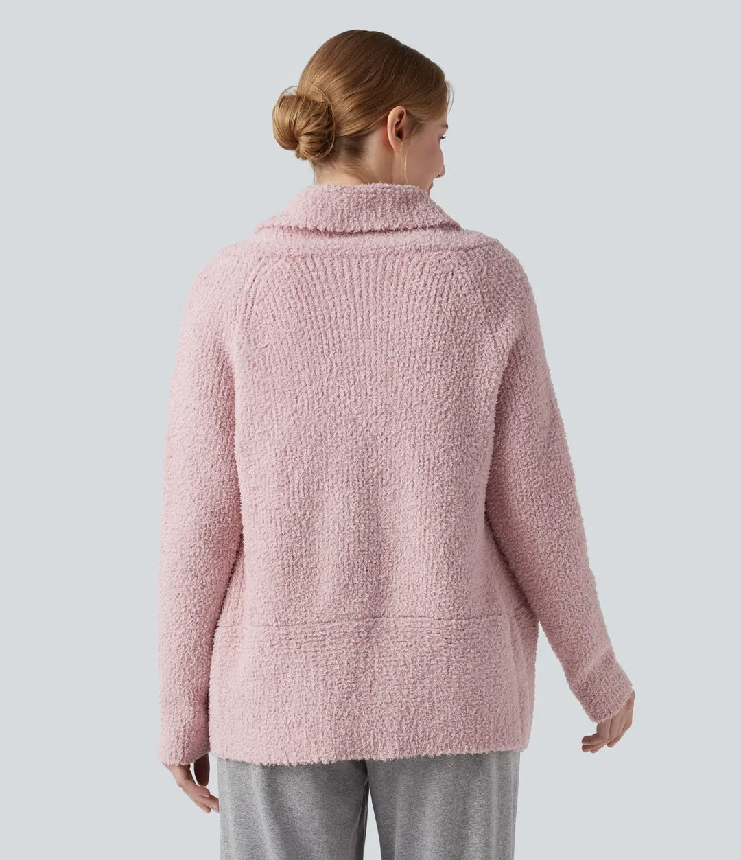 Baksidesvy av ljusrosa damcardigan med långa raglanärmar