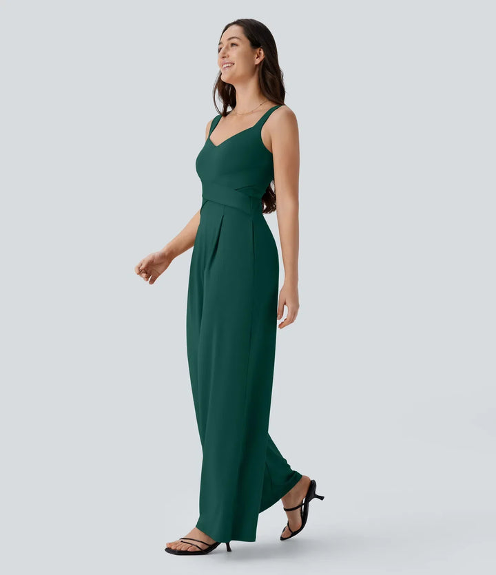 Sidoprofil av mörkgrön ärmlös jumpsuit med vida ben och fickor