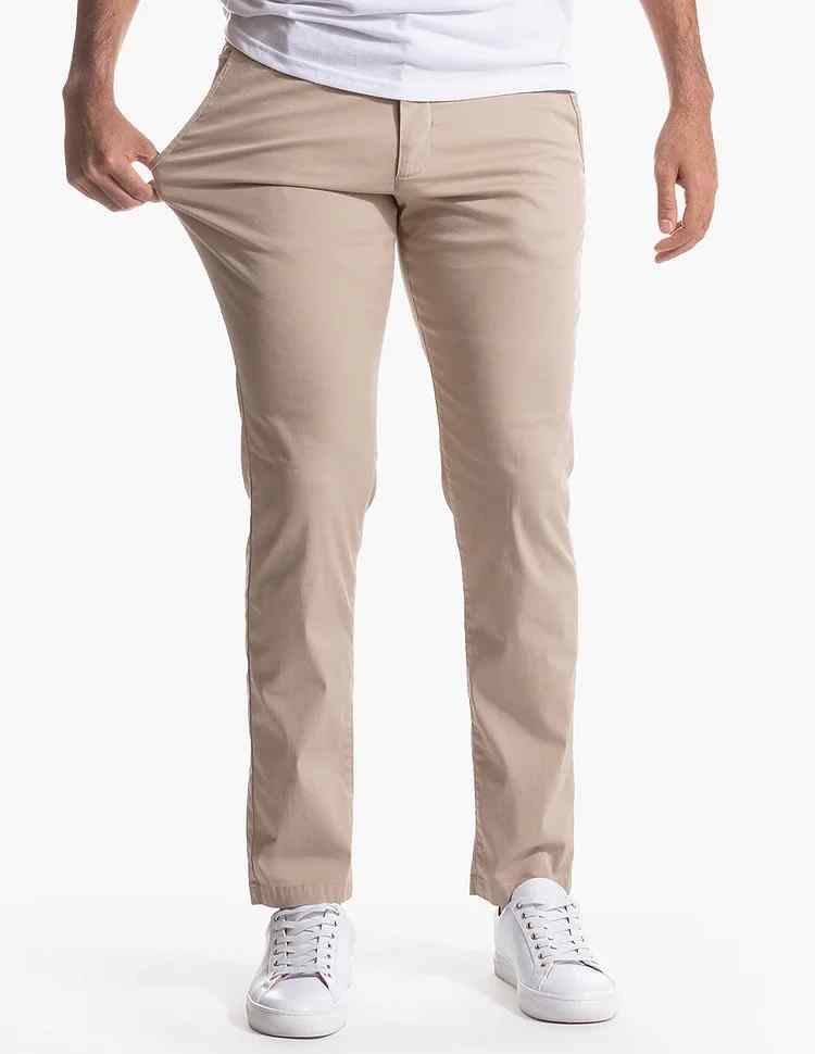 Man i stretchiga khaki byxor som visar elasticiteten
