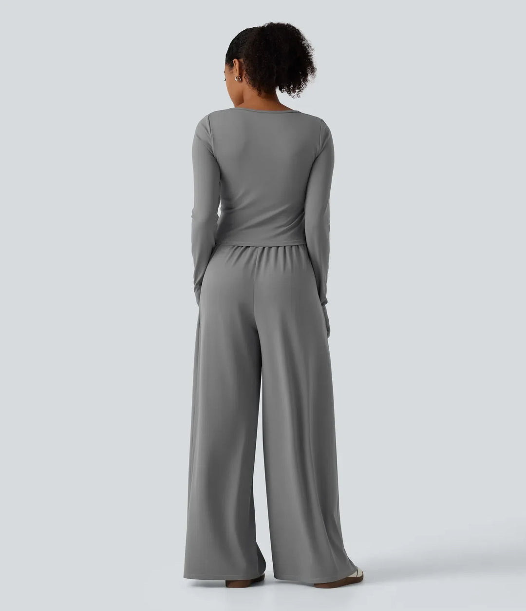 Baksidesvy av grå damjumpsuit med rynkad midja