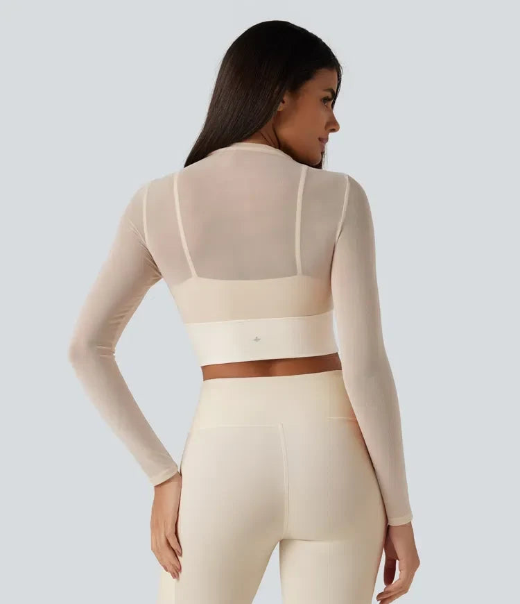 Bakifrån av dam i långärmad beige mesh yogatopp