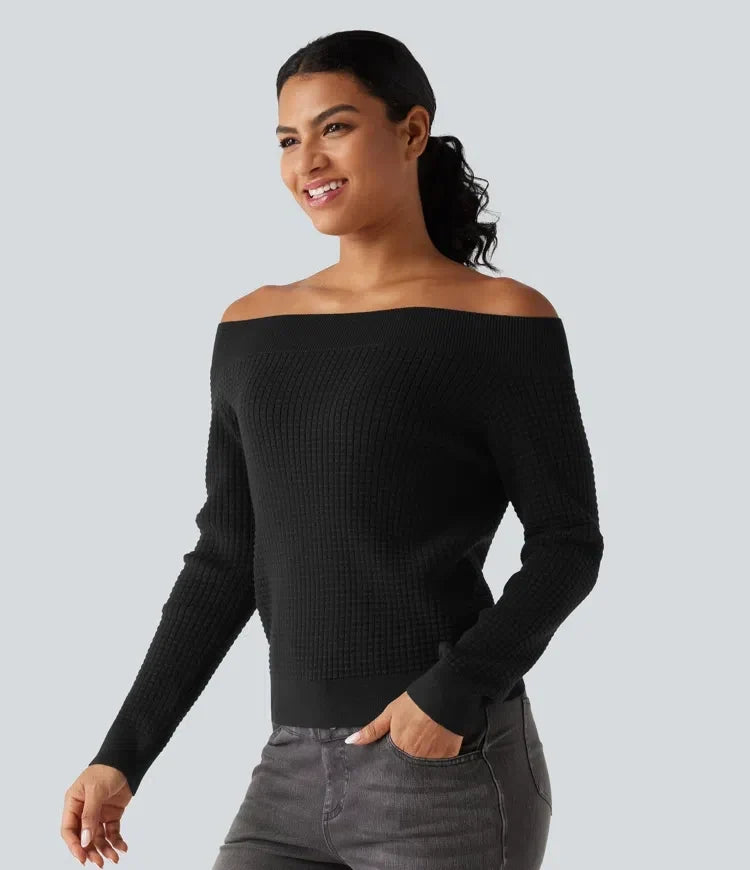 Kvinna i svart tröja med off-shoulder design poserande i profil