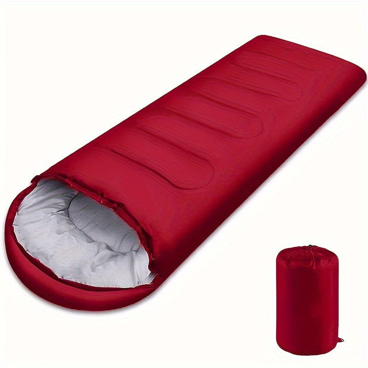 Röd sovsäck med huva och tillhörande packpåse för camping
