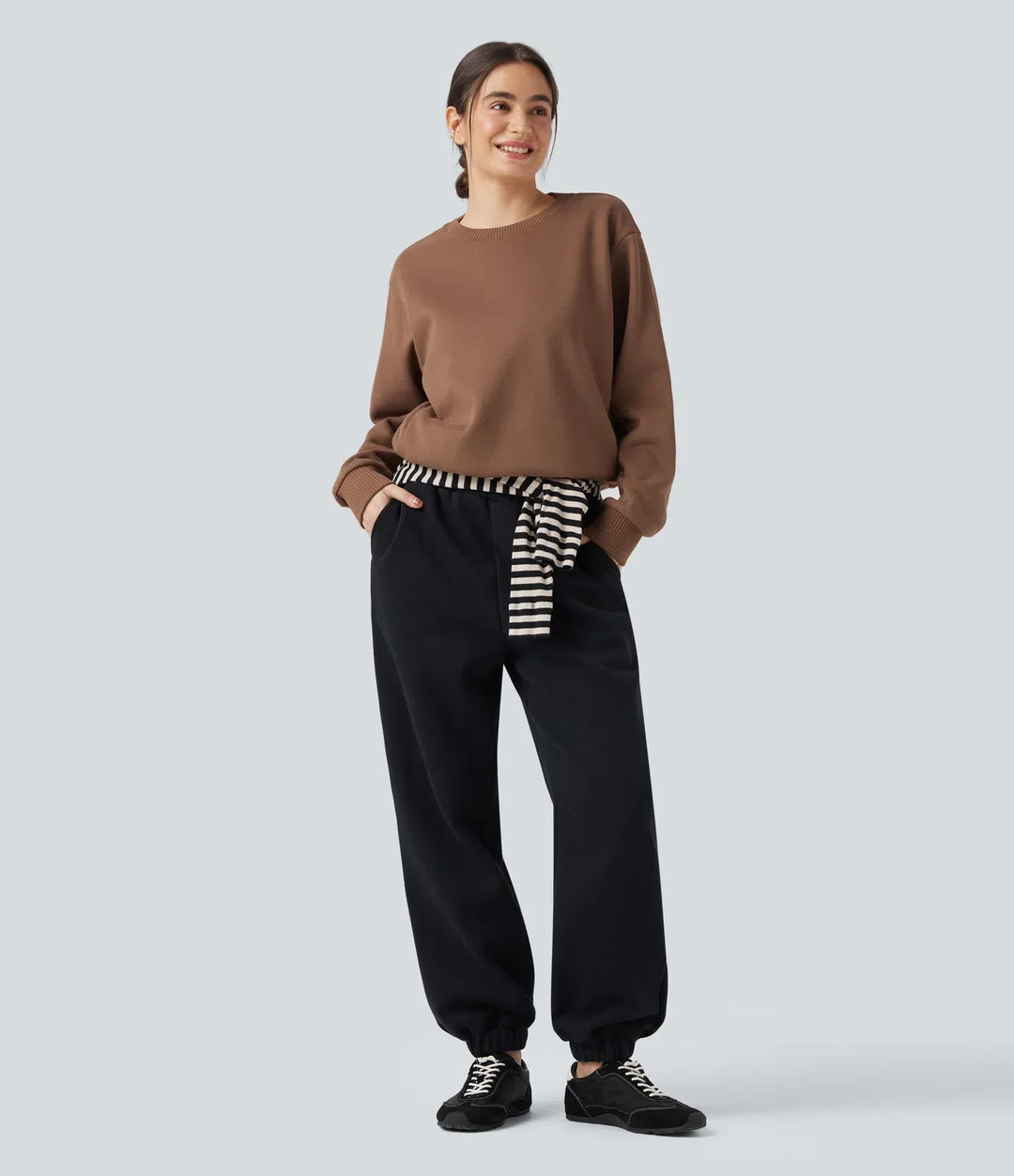 Närbild på tygdetaljer och ficka på långärmad sweatshirt för dam