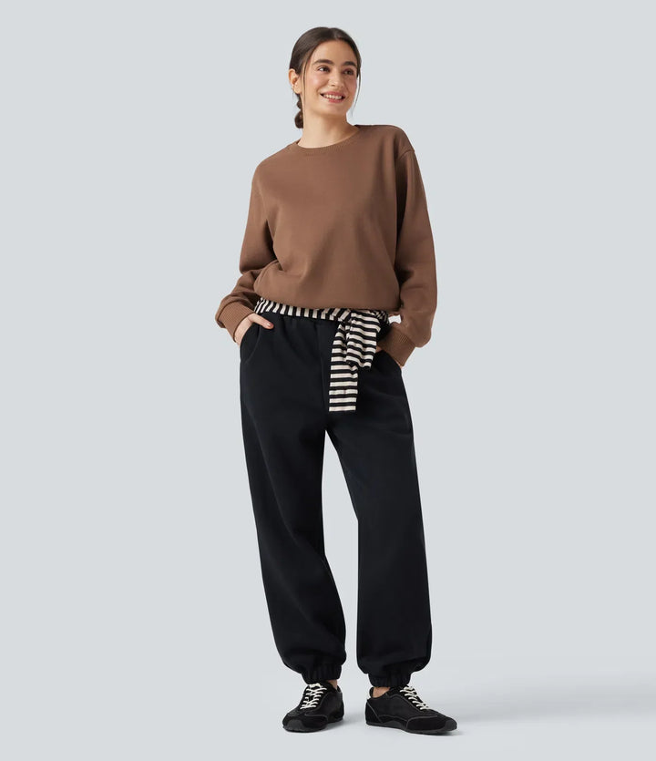 Närbild på tygdetaljer och ficka på långärmad sweatshirt för dam