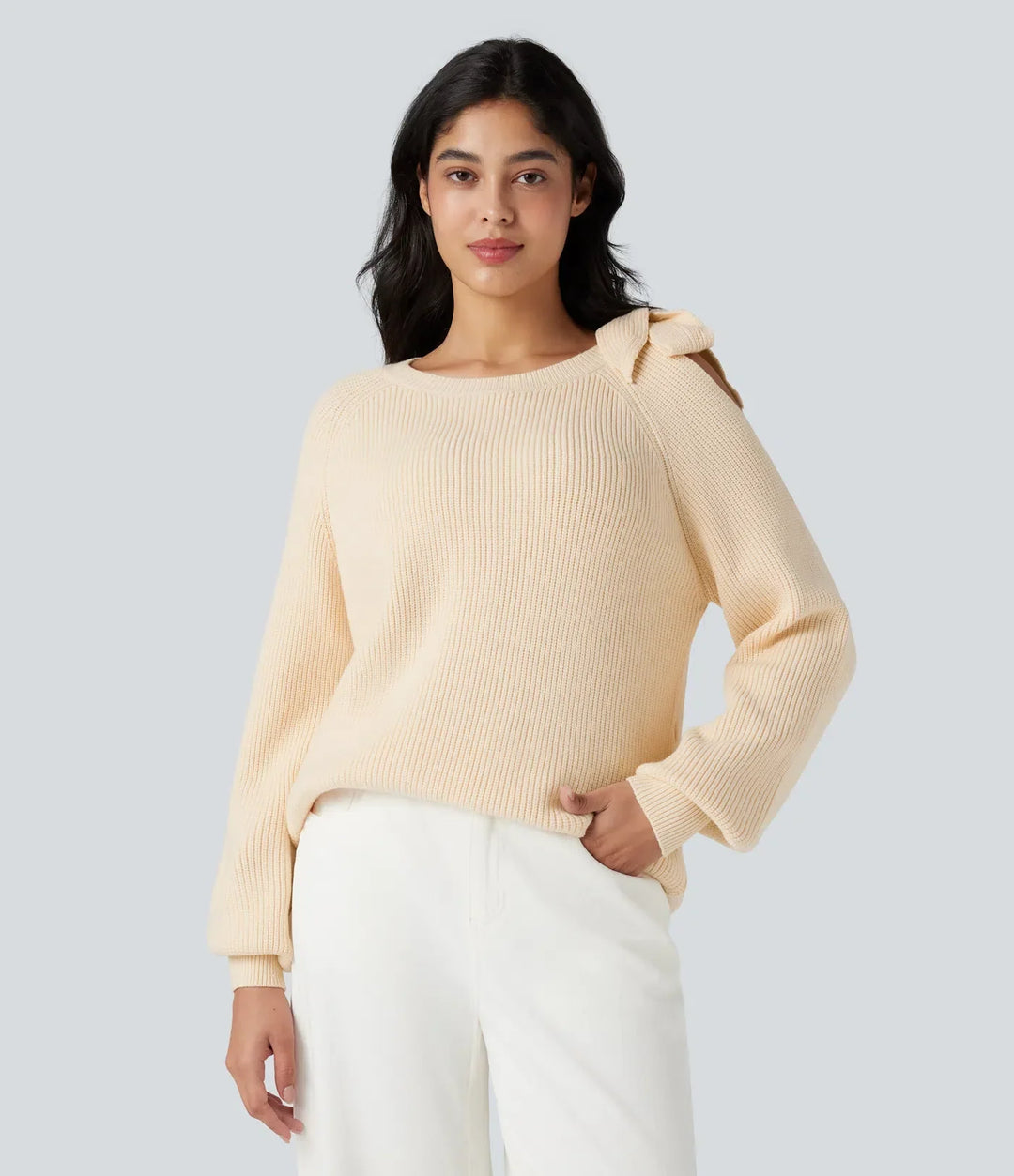 Beige stickad tröja med rund hals visas bakifrån