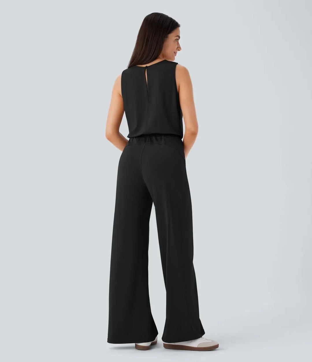 Baksida av svart damjumpsuit med nyckelhålsdetalj i nacken
