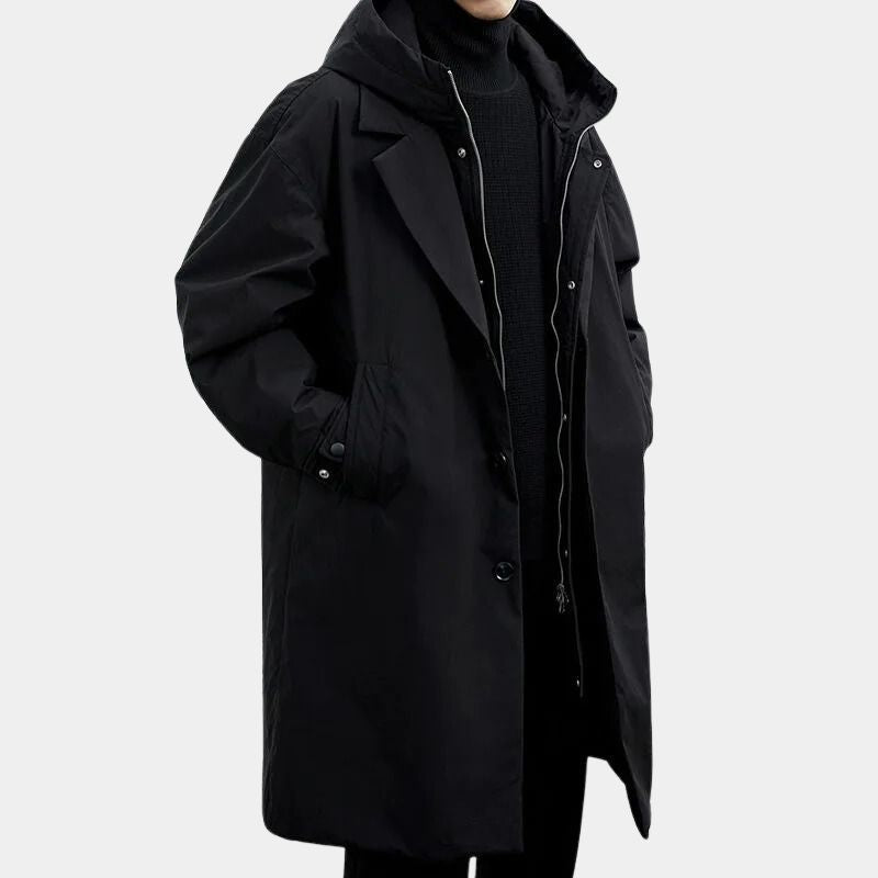 Svart herrtrenchcoat med huva och tvåradig knäppning på modell