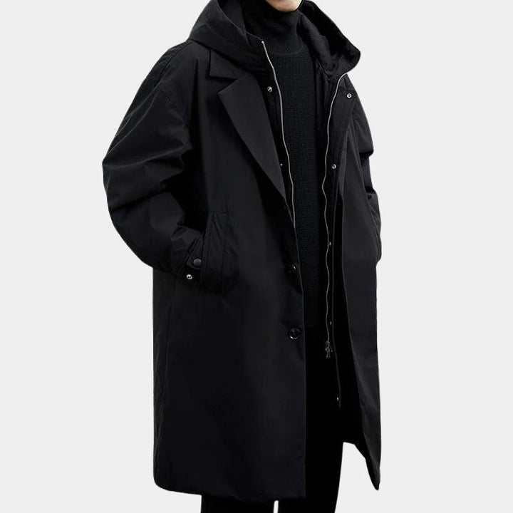 Svart herrtrenchcoat med huva och tvåradig knäppning på modell
