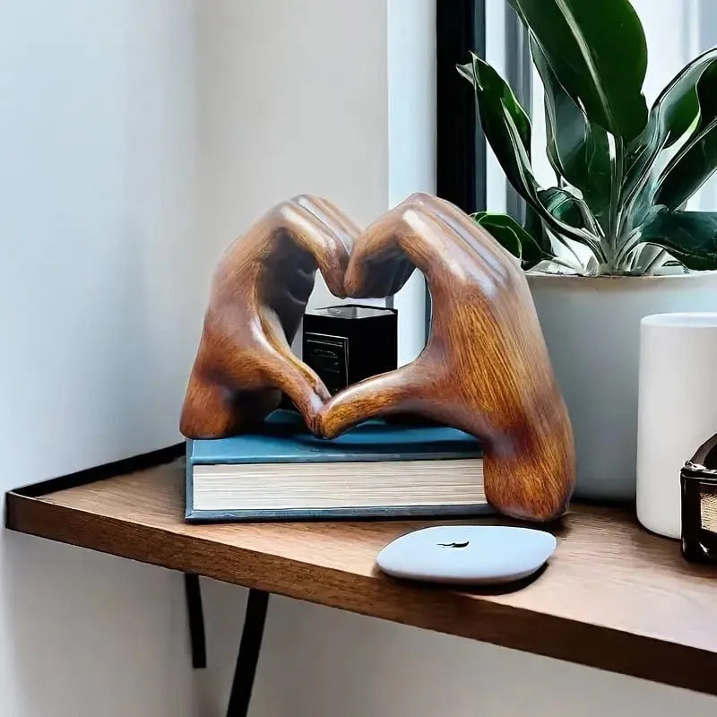 Hjärtformad konstnärlig skulptur på hylla med bok