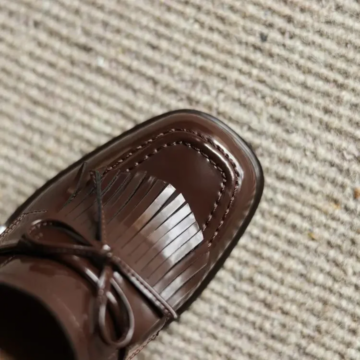 Bakre vy av svarta damloafers som visar den bekväma blockklacken