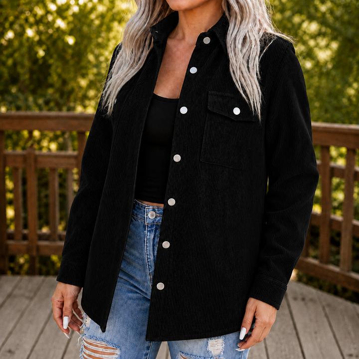 Kvinna i svart strukturerad skjortjacka med svarta kläder och jeans