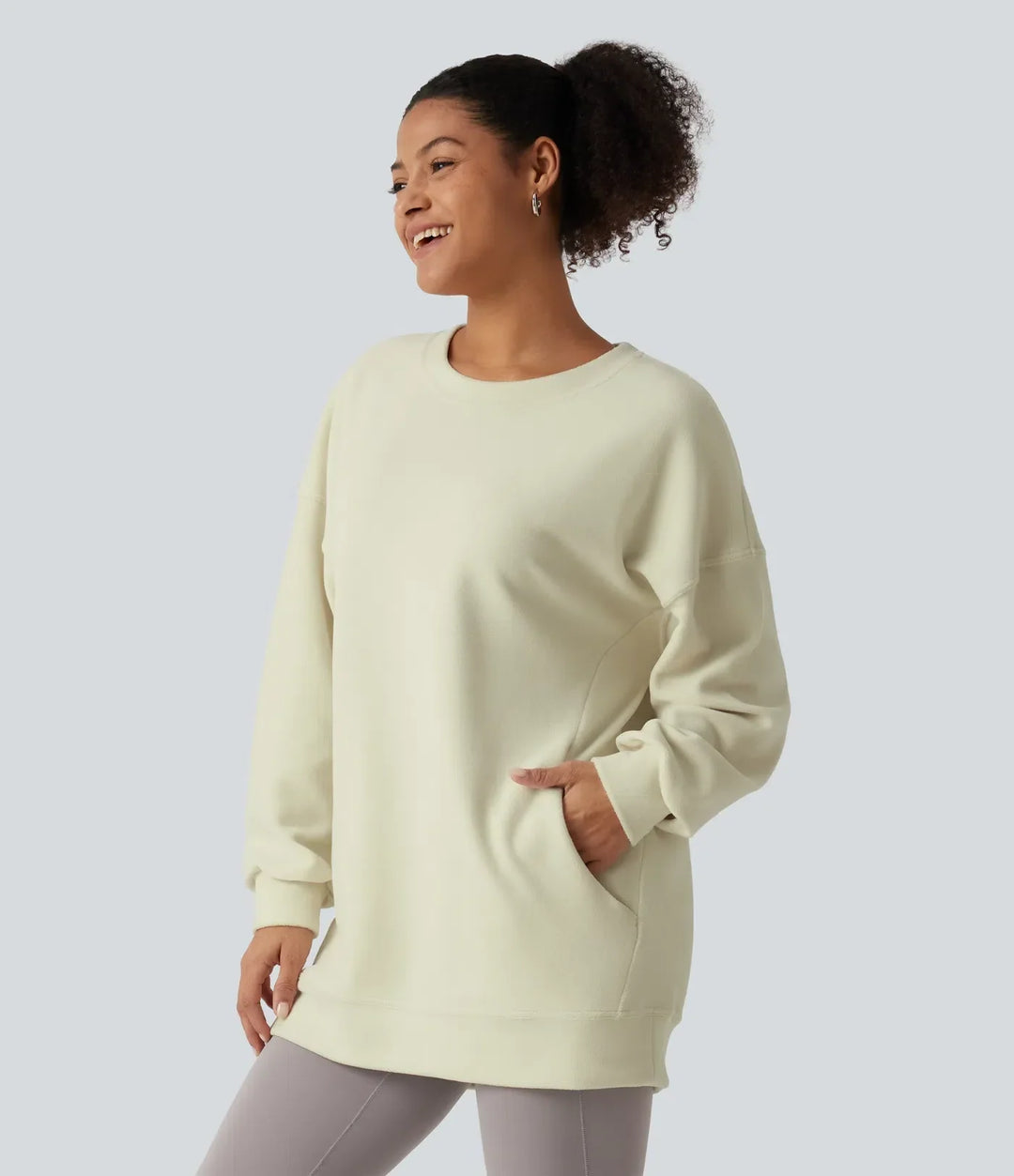 Kvinna i profil som visar den bekväma passformen och praktiska sidofickan på sweatshirt